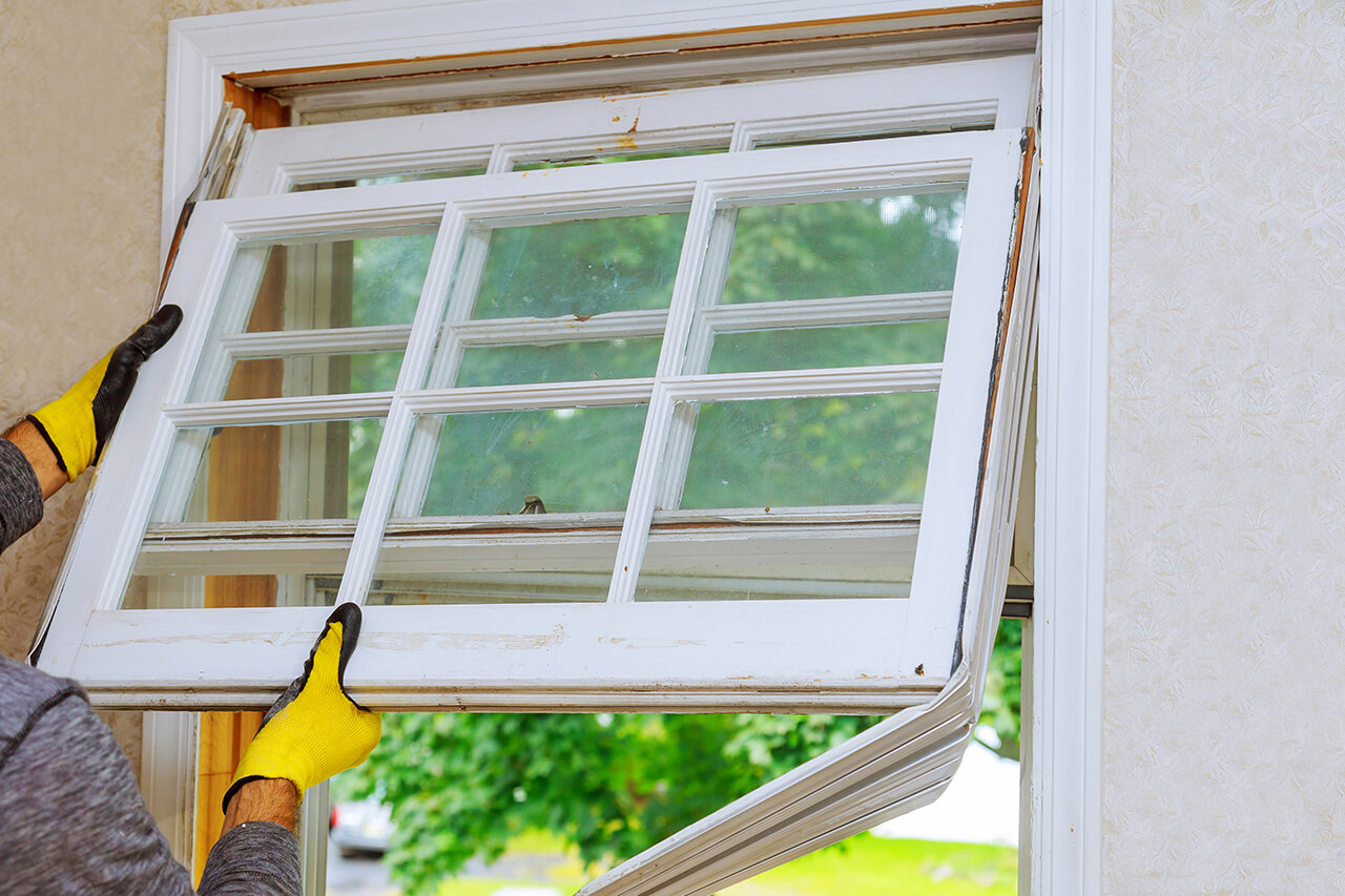 professional repairing an old window in a home