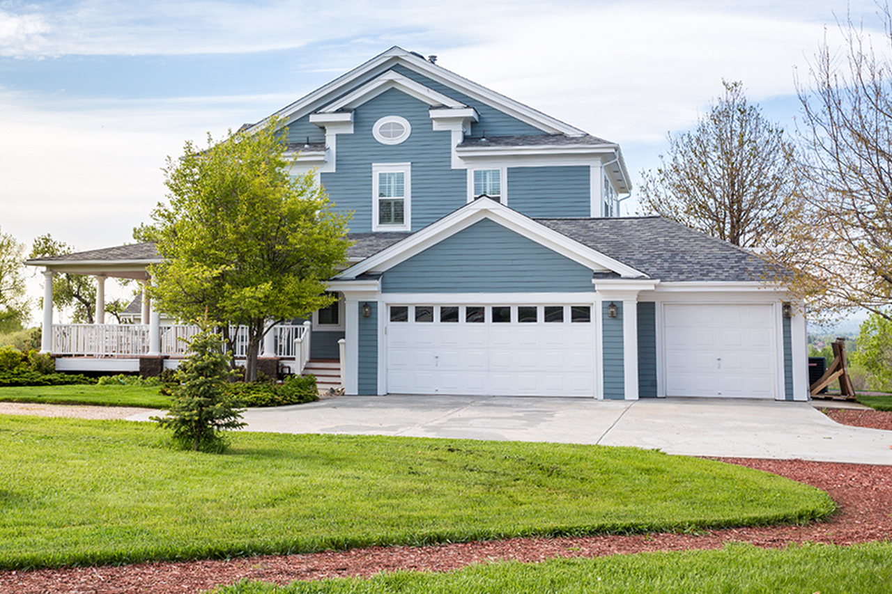 A blue house with a well-manicured lawn