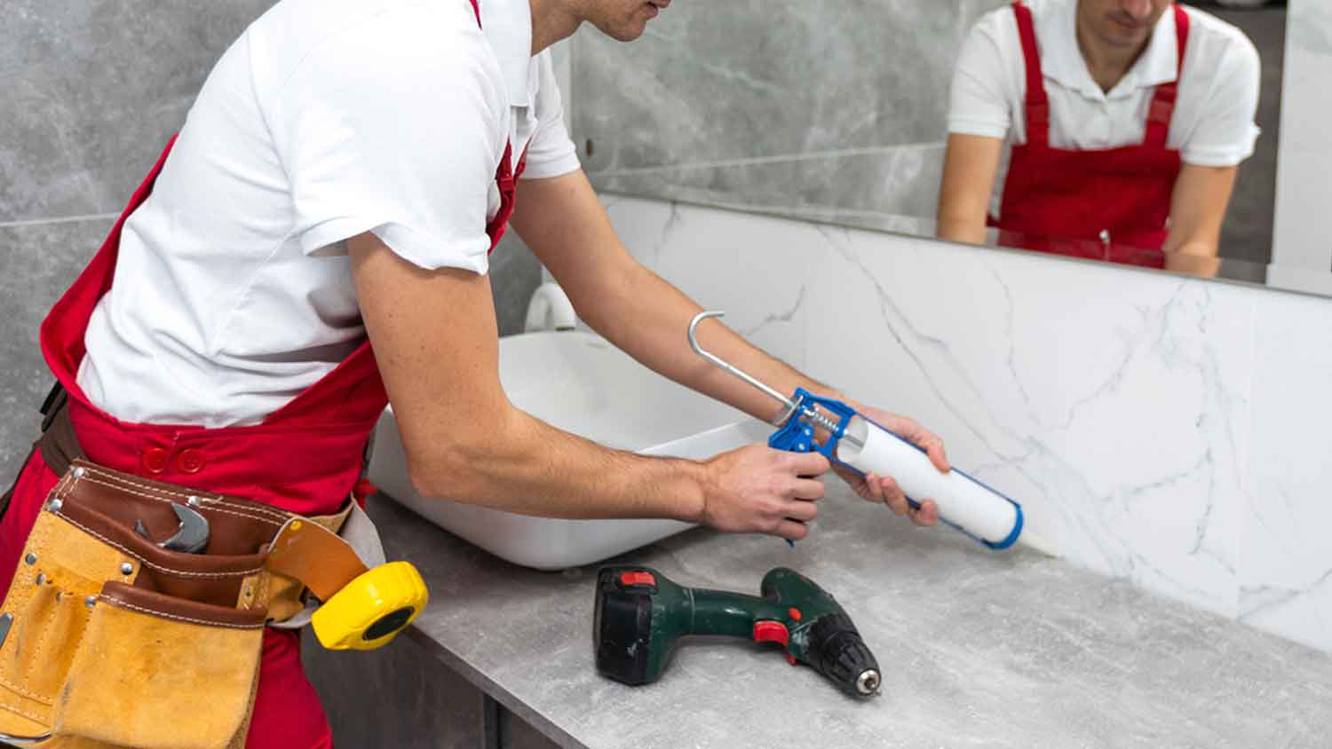 Plumber caulking bathroom vanity top