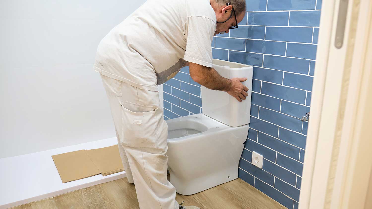 Plumber installing new toilet in the bathroom