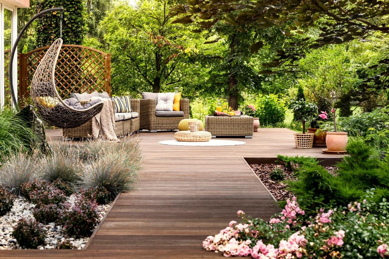 A wooden patio with nice furniture and lots of plants